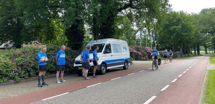 Lopers en begeleidingsbus op de weg